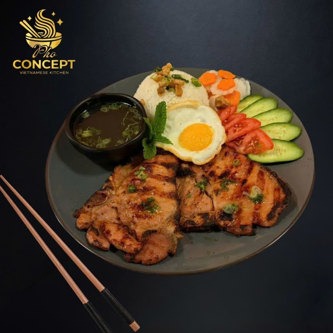 Com tam with grilled pork chop, sunny-side egg, pickles, cucumber, and soup