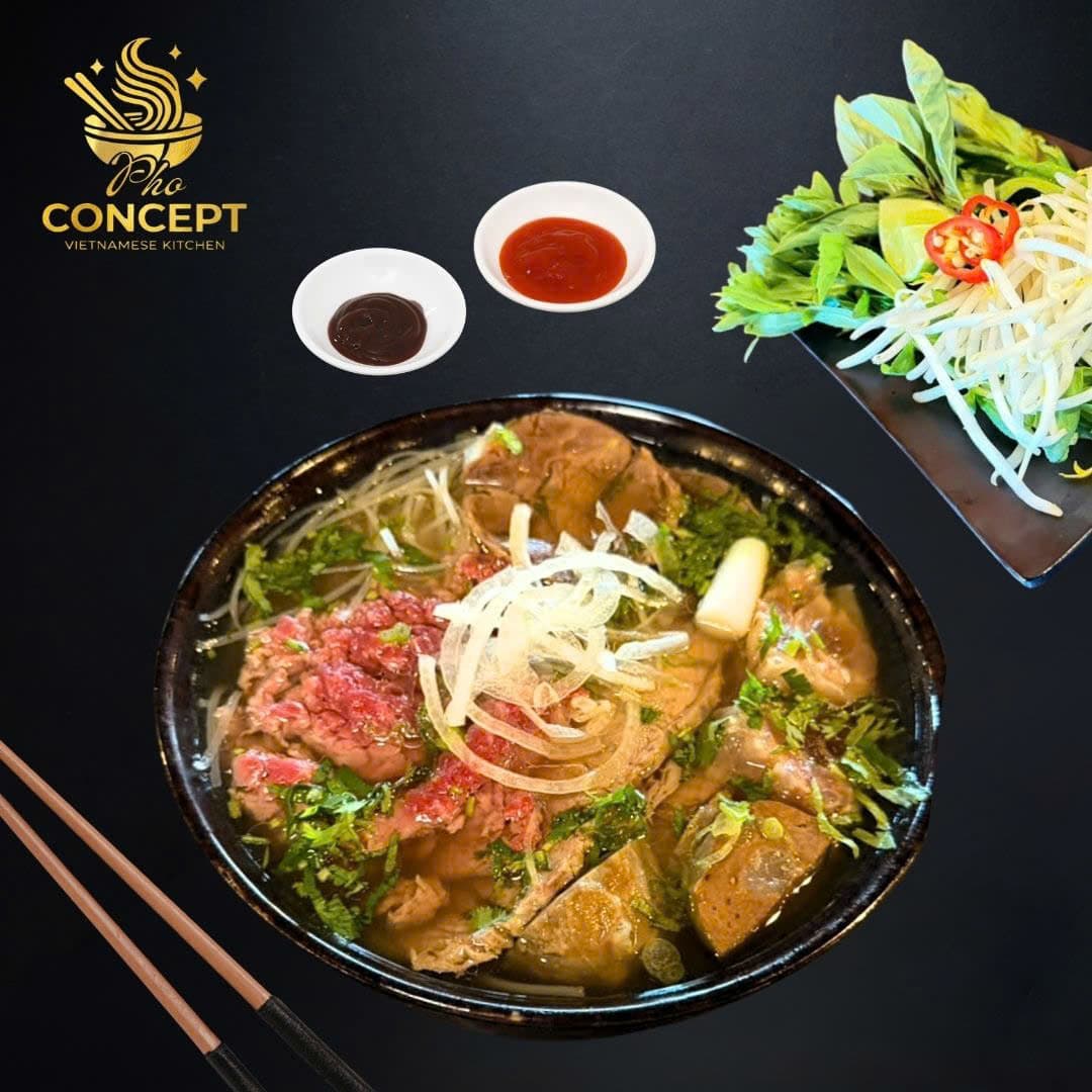 Bowl of pho bo with rare beef, beef cuts, herbs, and bean sprouts